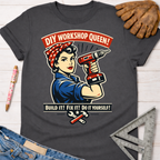 Women's funny woodworking graphic tee shirt for female woodworkers, makers, and DIY builders — Sawdust & Ponytails. Dark gray t-shirt with a Rosie the Riveter-style graphic holding a drill, text "DIY Workshop Queen!" and "Build It! Fix It! Do It Yourself!".