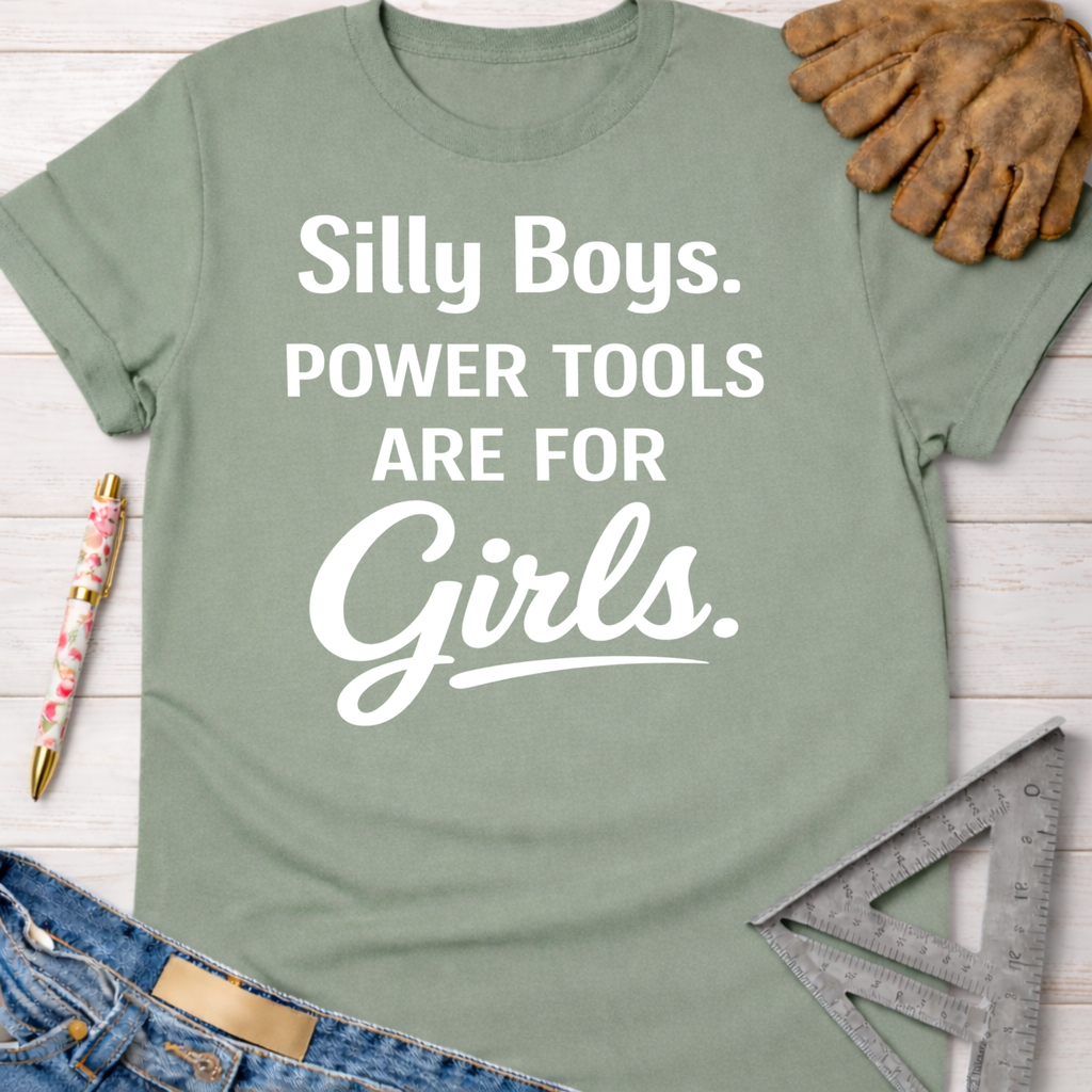 Women's funny woodworking graphic tee shirt for female woodworkers, makers, and DIY builders — Sawdust & Ponytails. Sage green cotton tee with "Silly Boys. Power Tools Are For Girls." in white text.