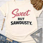 Women's funny woodworking graphic tee shirt for female woodworkers, makers, and DIY builders — Sawdust & Ponytails. Cream t-shirt with "Sweet BUT SAWDUSTY." in pink and black script.