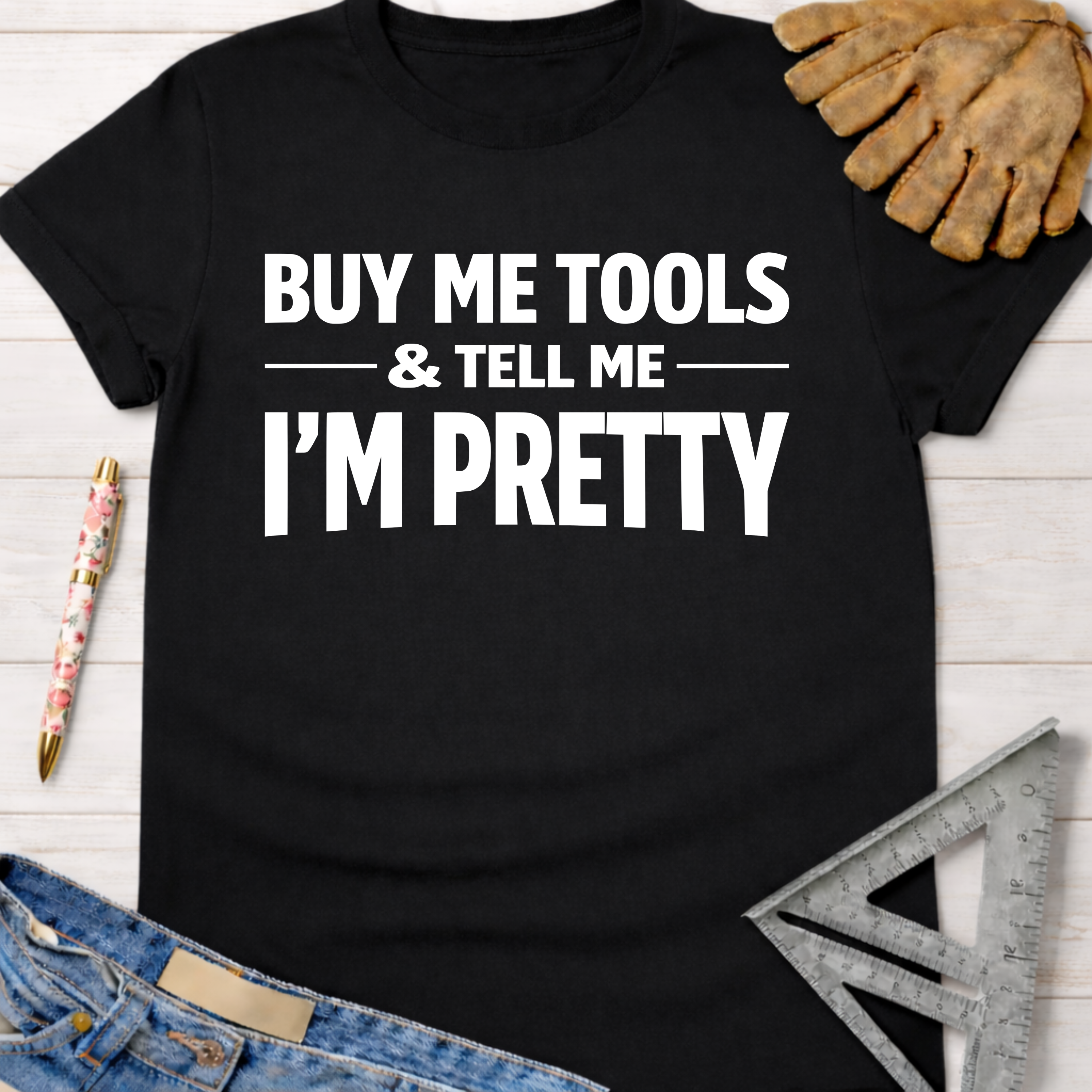 Black cotton "Buy Me Tools & Tell Me I'm Pretty" graphic tee with work gloves, jeans, and ruler.