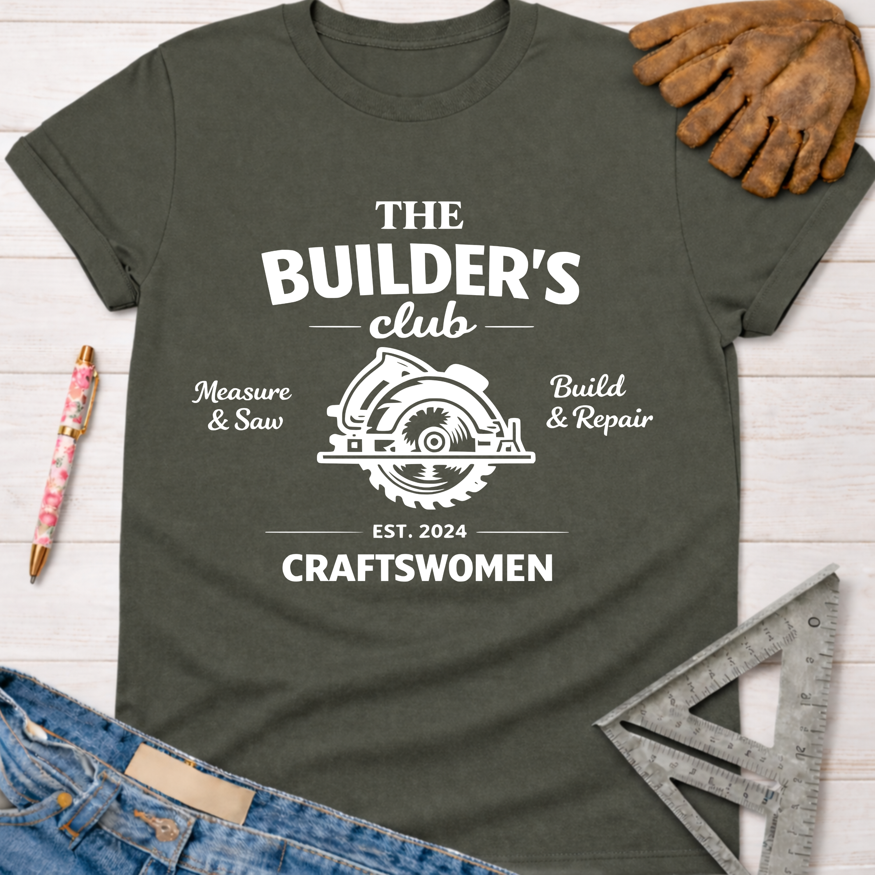 Women's funny woodworking graphic tee shirt for female woodworkers, makers, and DIY builders — Sawdust & Ponytails. Dark gray cotton tee with "The Builder's Club" circular saw graphic.