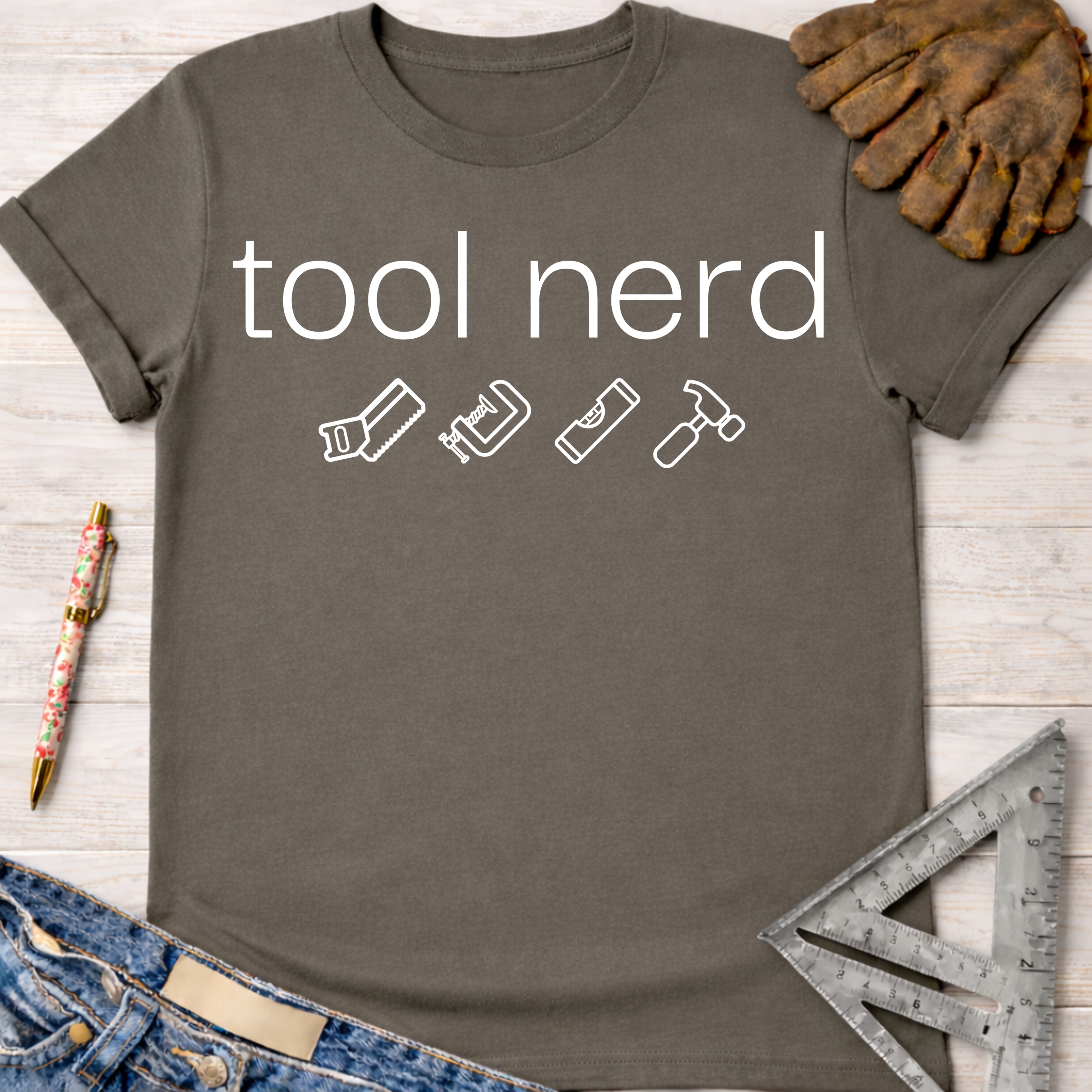 Women's funny woodworking graphic tee shirt for female woodworkers, makers, and DIY builders — Sawdust & Ponytails. Dark gray cotton t-shirt with "tool nerd" text and white tool icons.