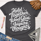 Charcoal gray women's "Held Together by Wood Glue and Impure Thoughts" graphic tee with work glove, pen, and ruler.