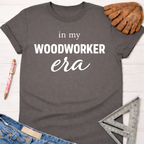 Women's funny woodworking graphic tee shirt for female woodworkers, makers, and DIY builders — Sawdust & Ponytails. Dark gray cotton tee with "in my WOODWORKER era" text.