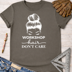 Women's funny woodworking graphic tee shirt for female woodworkers, makers, and DIY builders — Sawdust & Ponytails. Dark gray cotton tee with "Workshop Hair Don't Care" graphic and messy bun design.