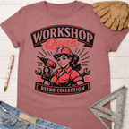 Women's funny woodworking graphic tee shirt for female woodworkers, makers, and DIY builders — Sawdust & Ponytails. Mauve retro t-shirt with "Workshop Queen Retro Collection" graphic featuring a woman in a hard hat holding a drill.