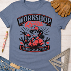 Women's funny woodworking graphic tee shirt for female woodworkers, makers, and DIY builders — Sawdust & Ponytails. Blue cotton tee with "Workshop Queen Retro Collection" graphic featuring a woman in a hard hat holding a drill.